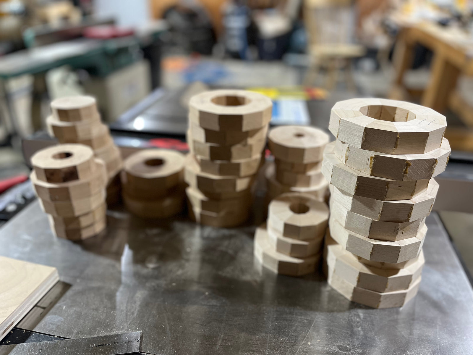 After the segments are cut, they are dry-fit into rings to check the joints. Once the fit looks good, the pieces are glued together and clamped into a complete ring.

When the glue has cured, each ring is flattened so it will sit tight against the next layer. This step is important because clean, flat rings create strong glue joints and a better-looking finished piece.

The rings are then stacked one at a time to build the rough form. Smaller rings may be used for the base or neck, while wider rings create the body of the piece. At this stage, the piece still looks blocky and unfinished, but the overall shape is starting to appear.