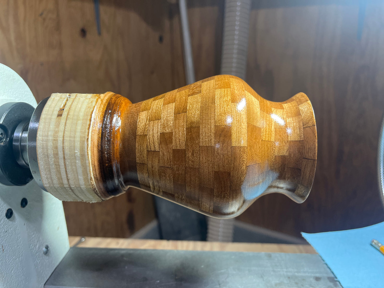 Once the stacked blank is complete, it is mounted on the lathe. The outside is turned first, removing the corners of the segments and shaping the piece into its final form.

As the piece is turned, the pattern of the segmented rings begins to show. The shape is refined by hand, whether it is a bowl, vase, bud vase, or decorative vessel.

After the turning is complete, the piece is sanded through multiple grits until the surface is smooth. Then the finish is applied. Some pieces receive a soft satin finish, while others are polished to a high gloss.